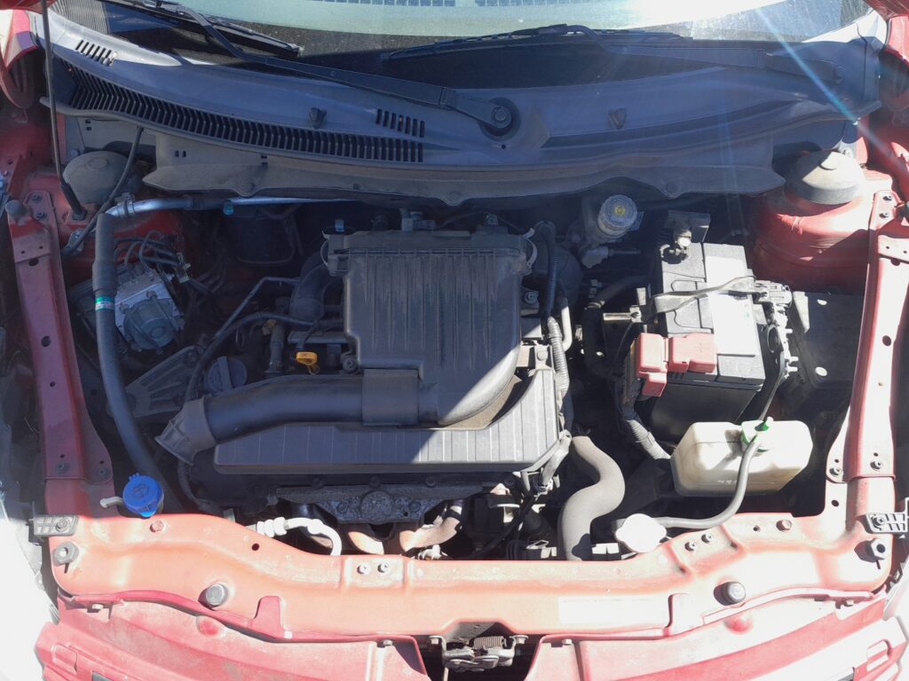 Suzuki Swift Mk3 (2010-2017) 12V battery in the engine bay, on the right with the red positive-terminal cover.