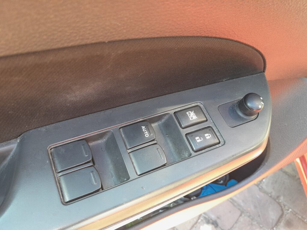 Suzuki Swift Mk3 driver door window switch panel with the AUTO switch, window lock and door-mirror control.