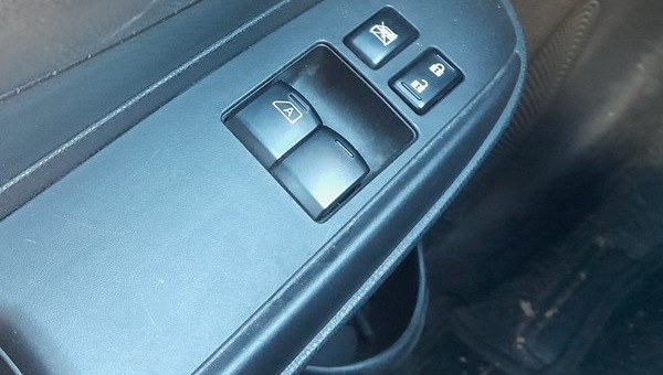 Driver's window switch with the AUTO one-touch symbol on the Nissan Note E12