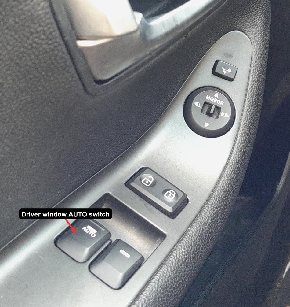 Kia Picanto TA driver door panel with the AUTO power-window switch arrowed
