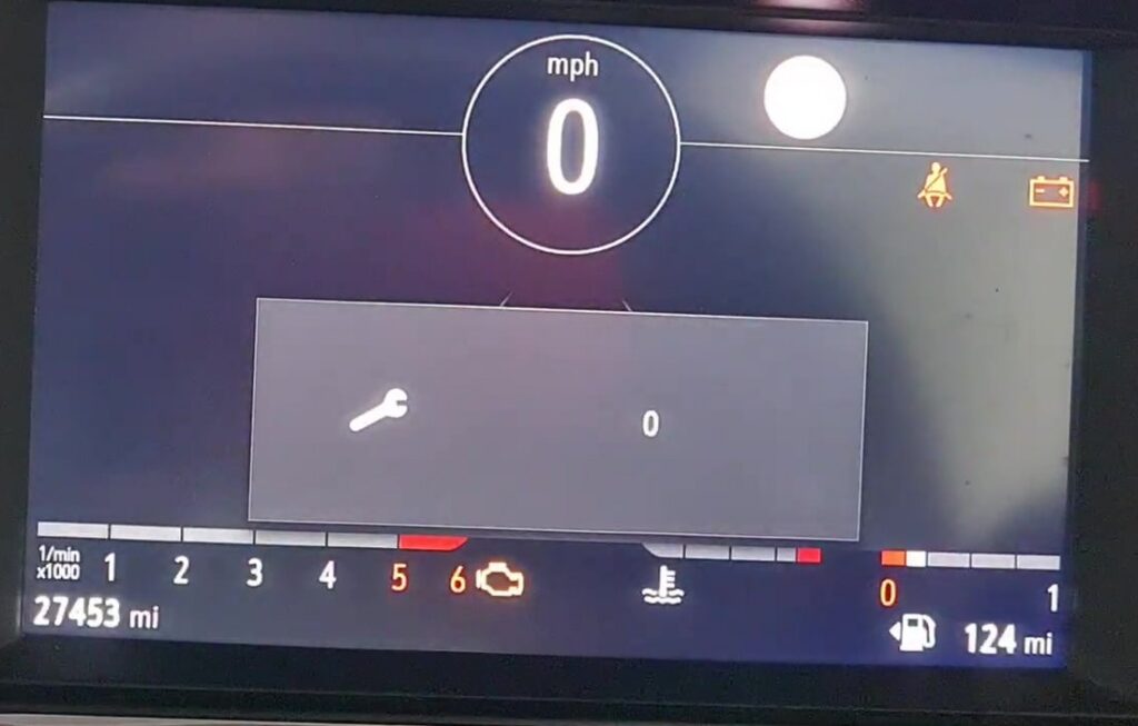 Vauxhall Corsa F digital instrument cluster showing the service maintenance wrench icon with the reset counter at zero.