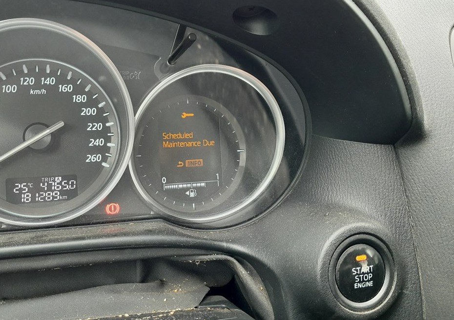 Mazda CX-5 instrument cluster showing the Scheduled Maintenance Due service reminder