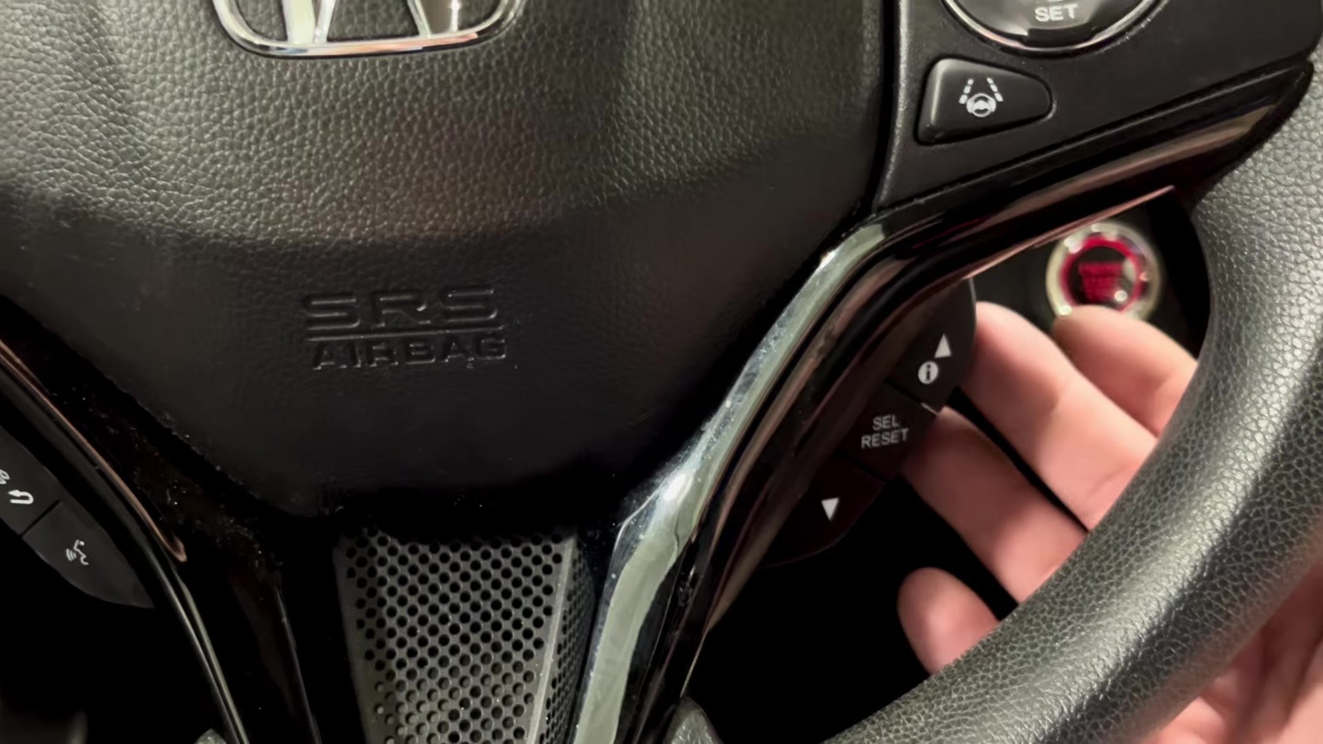 Honda HR-V Mk2 steering-wheel buttons: the i (Information) button with up and down arrows and the SEL/RESET button used to navigate the i-MID menu.