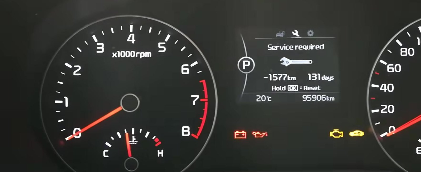 Kia Sportage Mk3 (SL) instrument cluster showing the Service Required reminder and Hold OK to Reset prompt