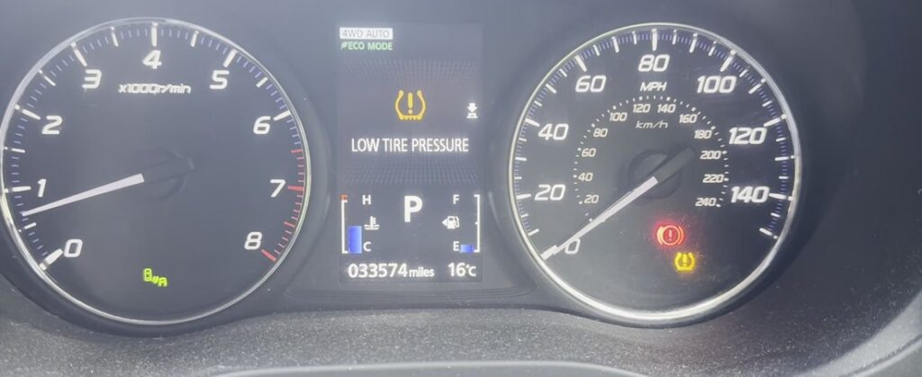 Mitsubishi Outlander Mk3 (GF) instrument cluster showing the LOW TIRE PRESSURE warning and amber TPMS tell-tale.