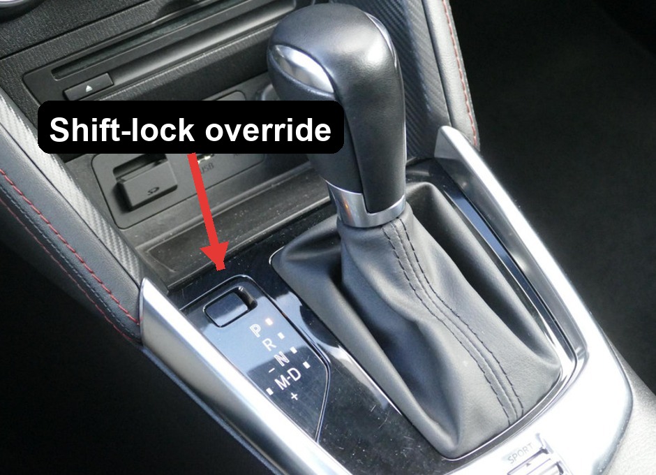 Mazda 2 DJ automatic gear selector with the shift-lock override cover above P arrowed