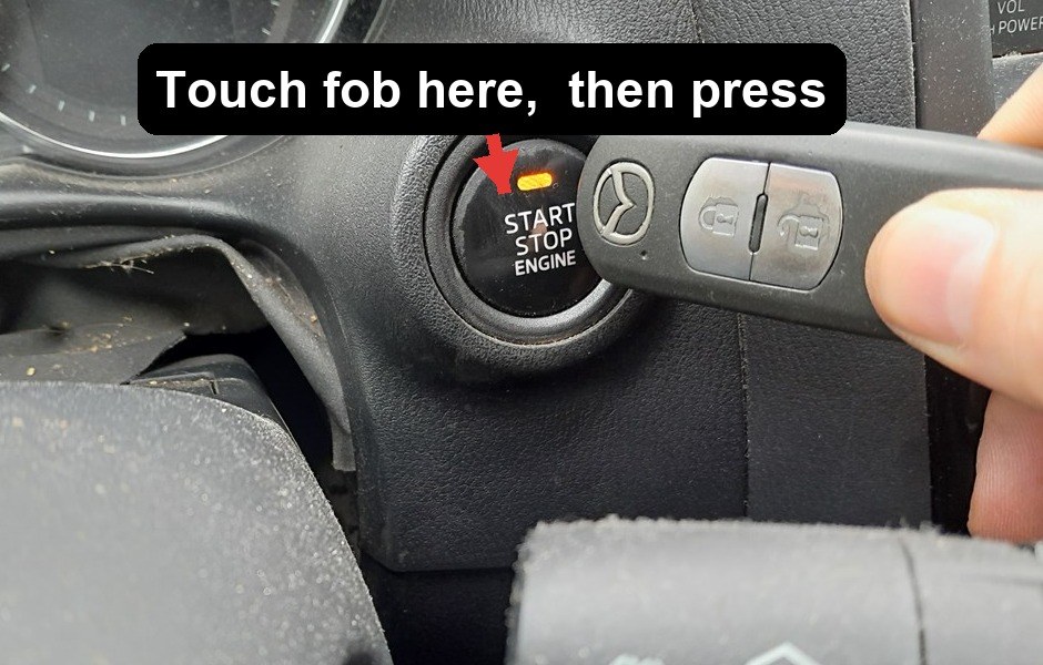 Holding the Mazda key fob against the START STOP ENGINE button in a CX-5