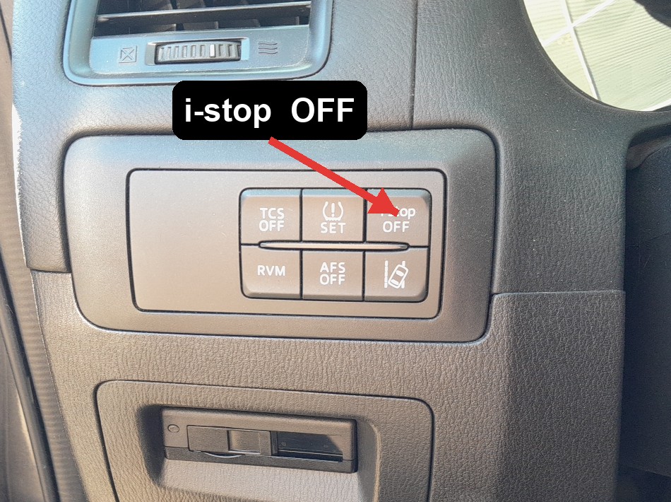 Red arrow pointing to the i-stop OFF button on the Mazda CX-5 switch panel