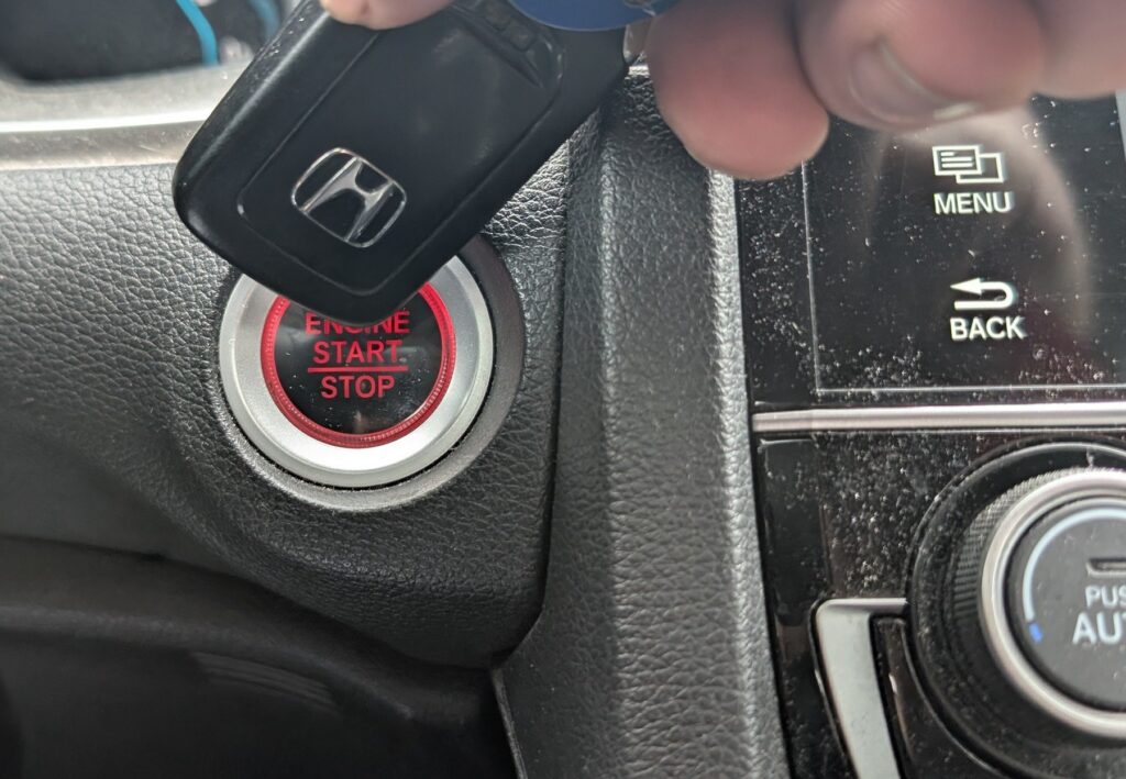 Holding a Honda smart key against the ENGINE START/STOP button