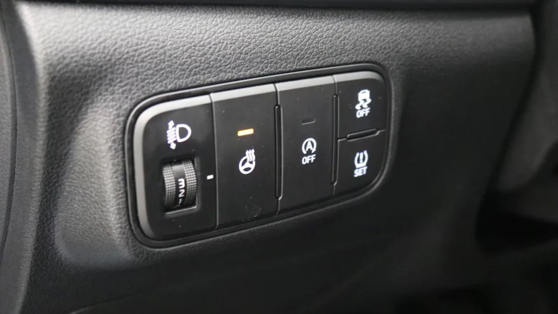 Hyundai i20 Mk3 lower-dash button panel showing the ISG auto stop-start OFF button (A in a circle), next to the headlight-leveling dial, heated steering wheel and ESC off buttons.