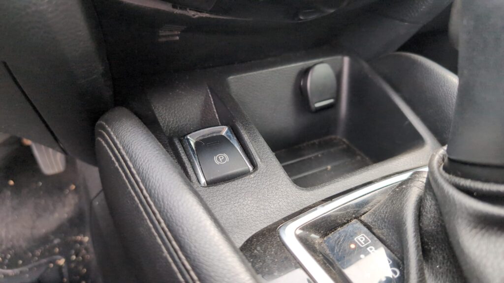 Centre-console electronic parking brake P switch on the Nissan Qashqai J11