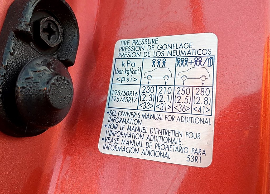 Tire-pressure placard in the driver's door jamb of a Suzuki Swift Mk4, showing 195/50 R16 and 195/45 R17 cold pressures.
