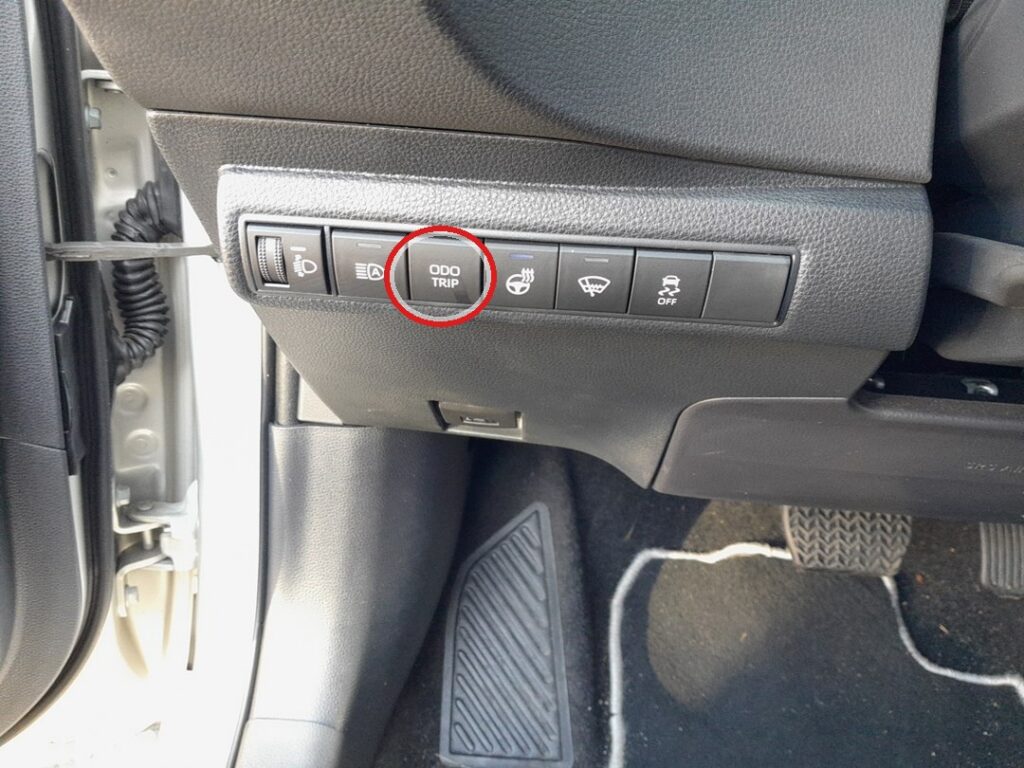 ODO TRIP reset button below the steering column on the Toyota Corolla Mk12 (E210)