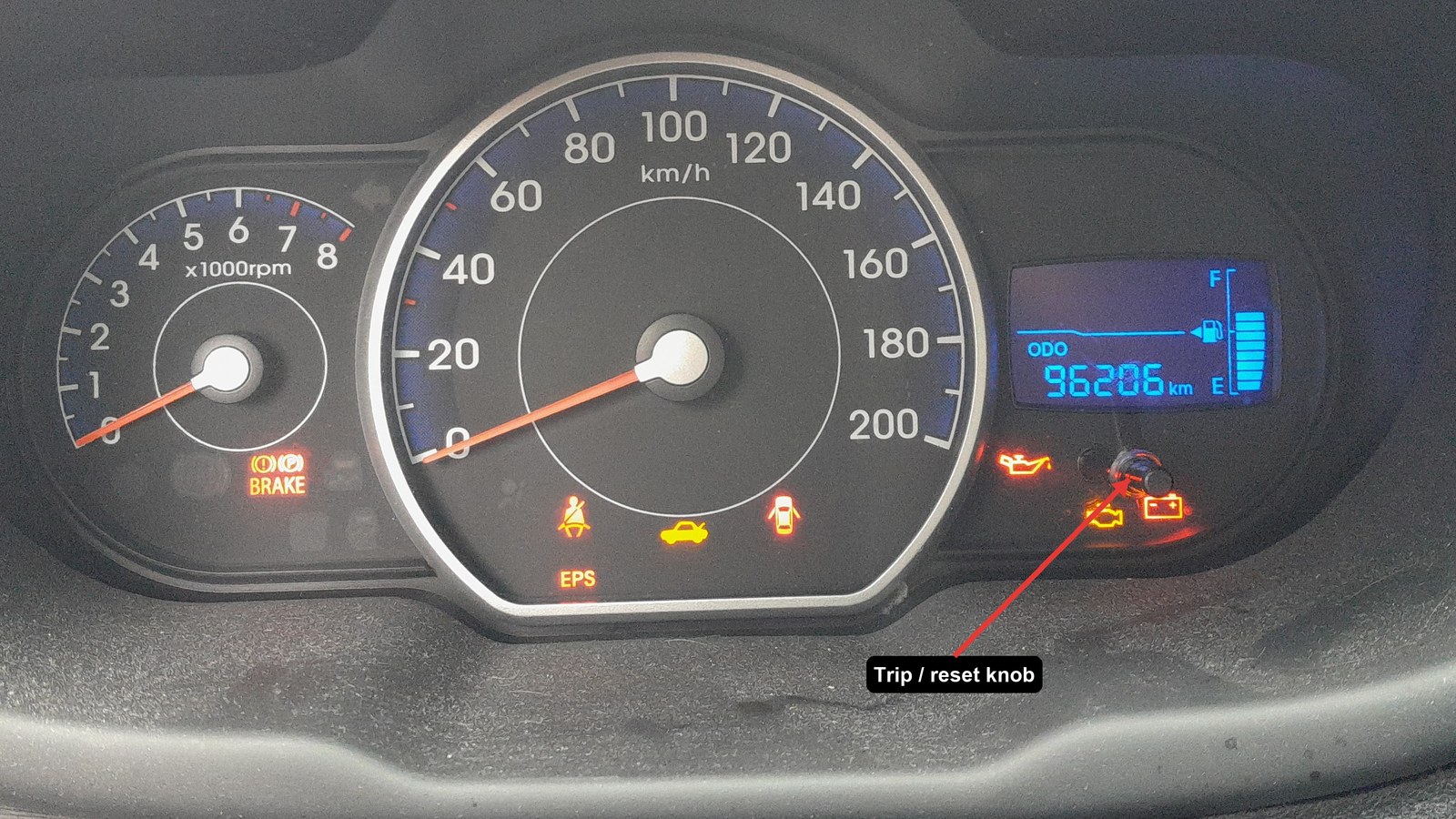 Hyundai i10 PA instrument cluster with the trip/reset knob arrowed