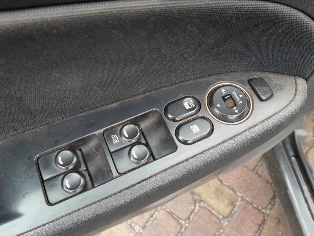 Driver's door window switch panel on the Hyundai i30 Mk1 (FD), showing the AUTO DOWN switch, window lock and mirror controls.