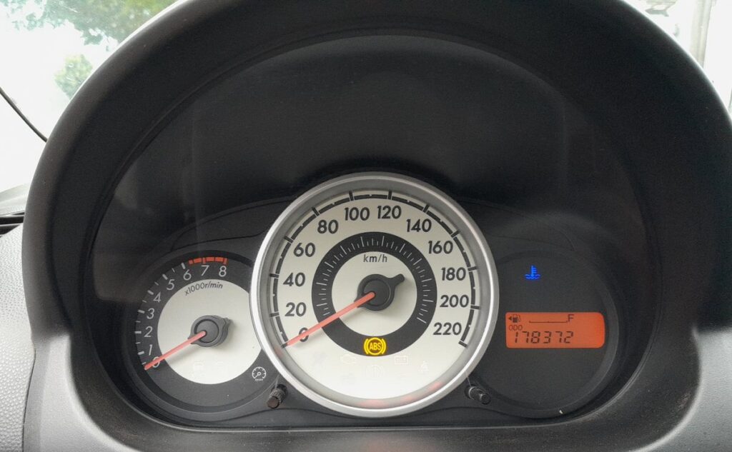 Mazda 2 DE instrument cluster showing the odometer and warning lights
