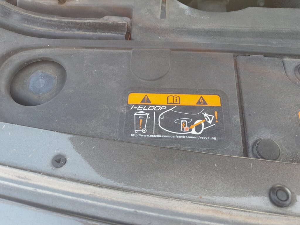 Mazda i-ELOOP capacitor label under the bonnet of a Mazda 6