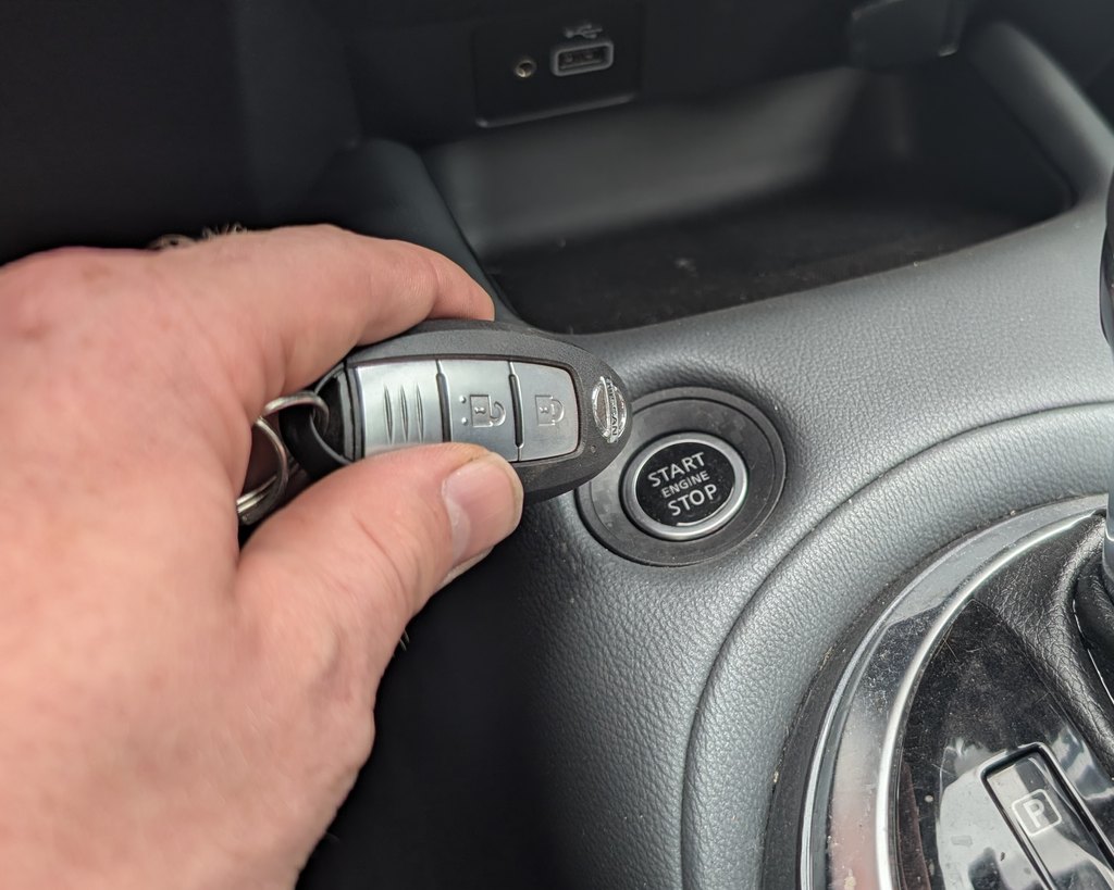 Holding the Nissan Intelligent Key against the START/STOP button on the Juke (F16)