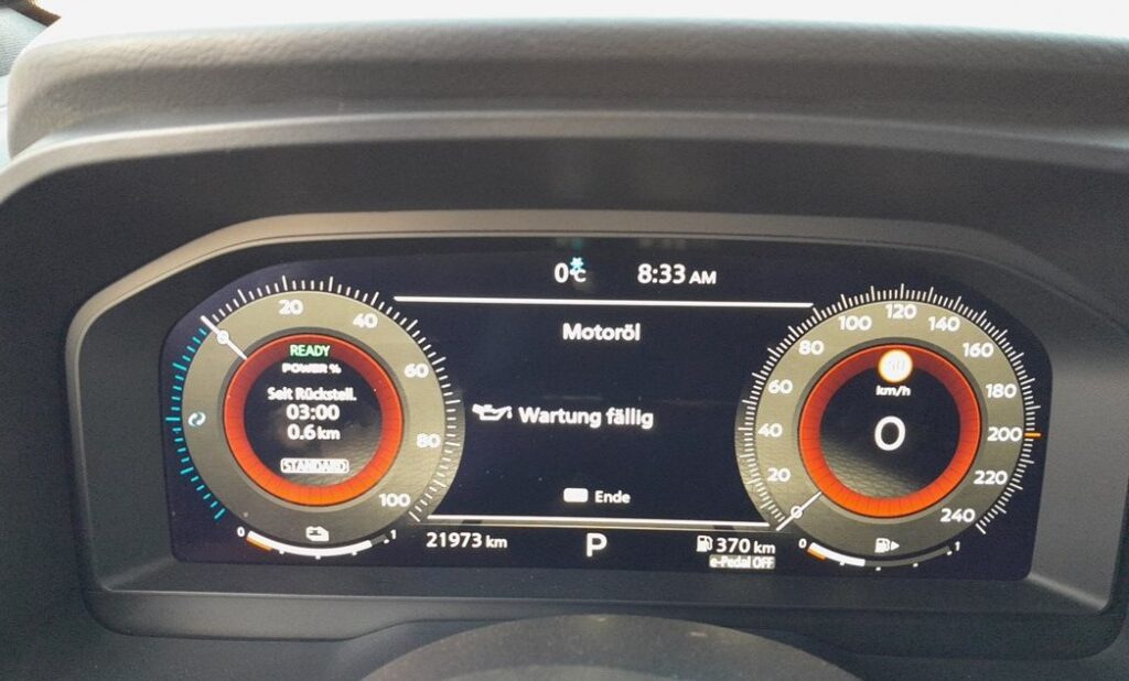 Nissan Qashqai J12 digital instrument cluster showing an oil-service reminder