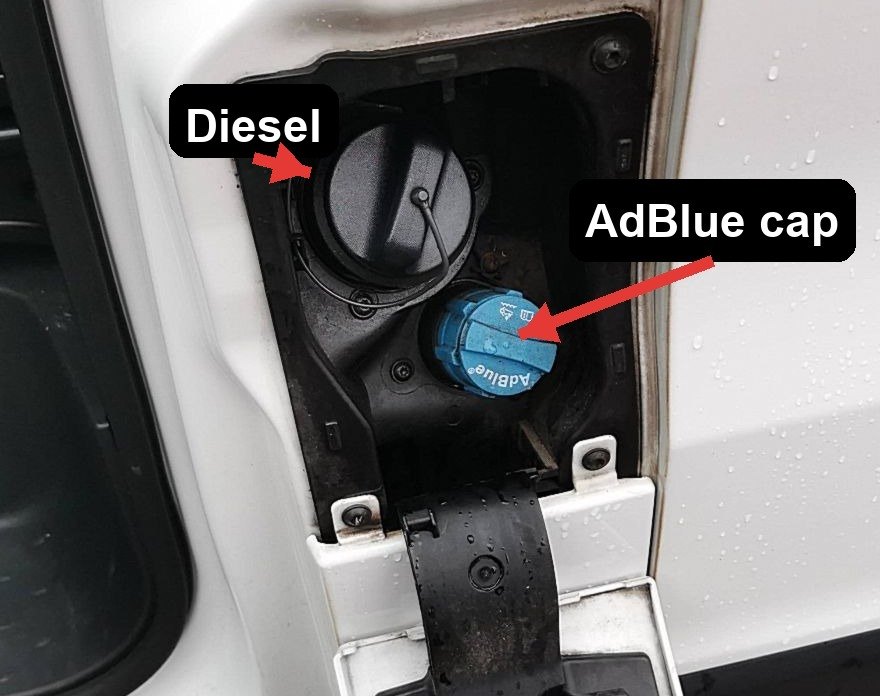 The blue AdBlue filler cap beside the black diesel cap, behind the van fuel flap
