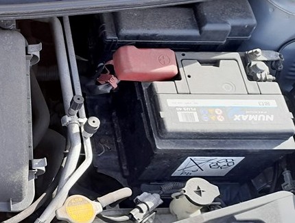 Toyota Aygo 12-volt battery in the engine bay with the positive and negative terminals