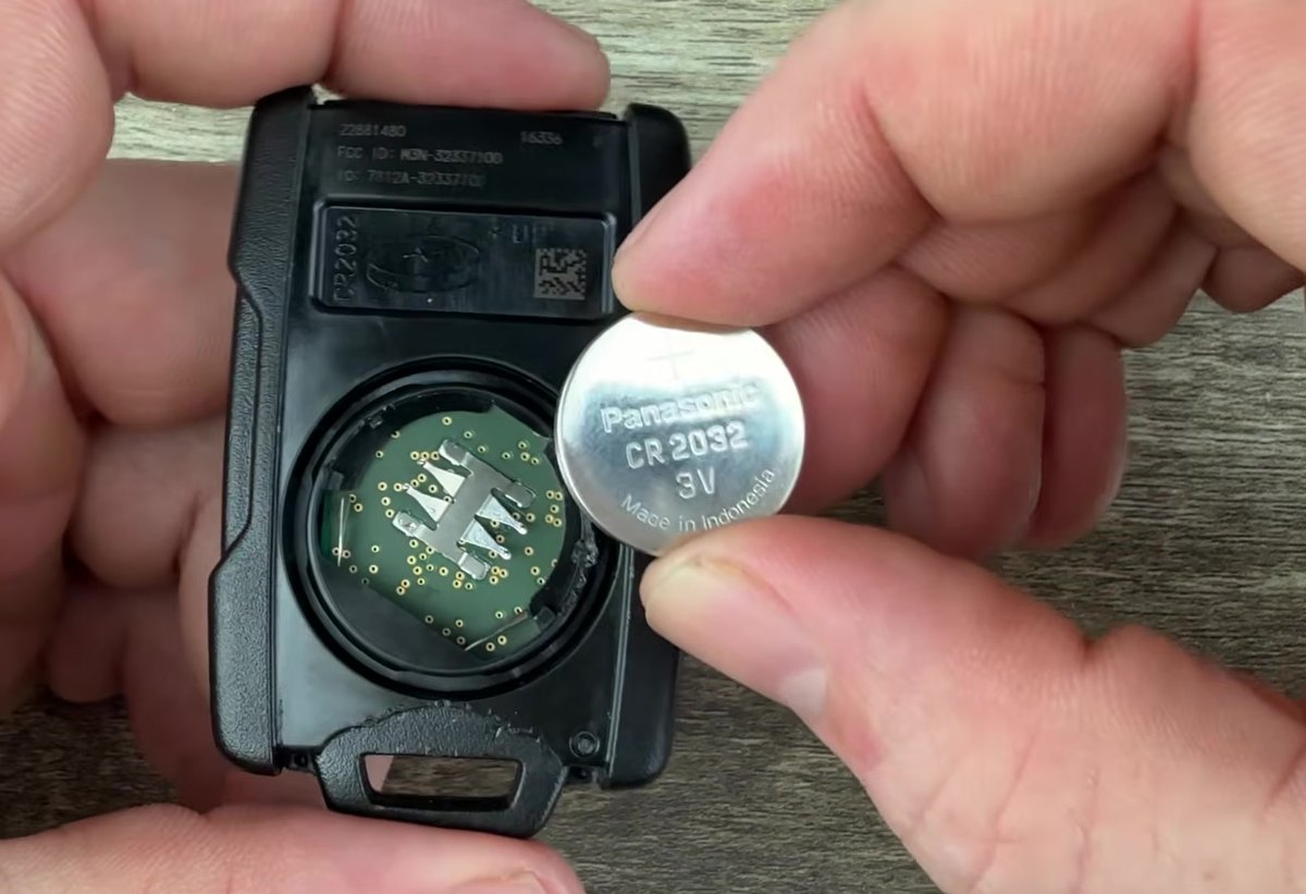 Silverado key fob opened, showing the CR2032 3V coin cell lifted out of the battery bay