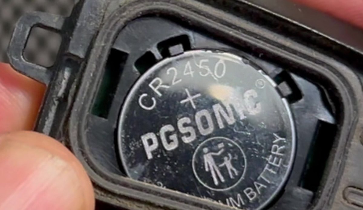 Ford F-150 P702 push-button smart key opened, showing a CR2450 coin cell in the battery bay