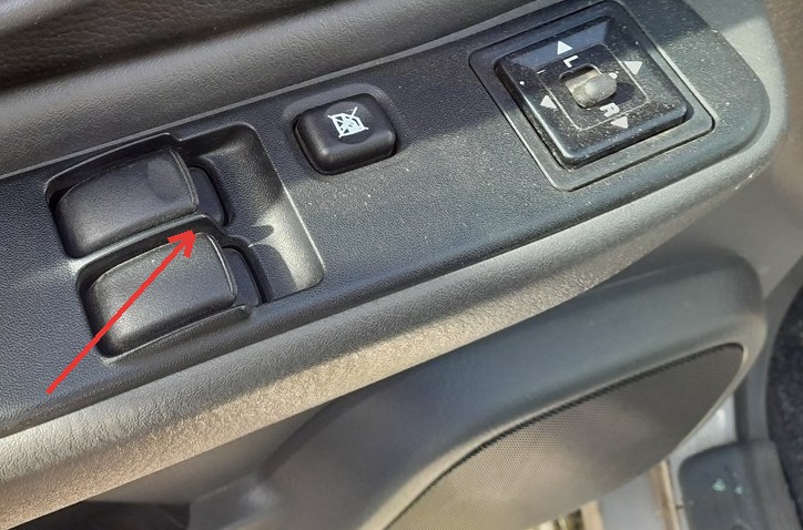 Mitsubishi L200 driver door power window switches with the driver window rocker arrowed