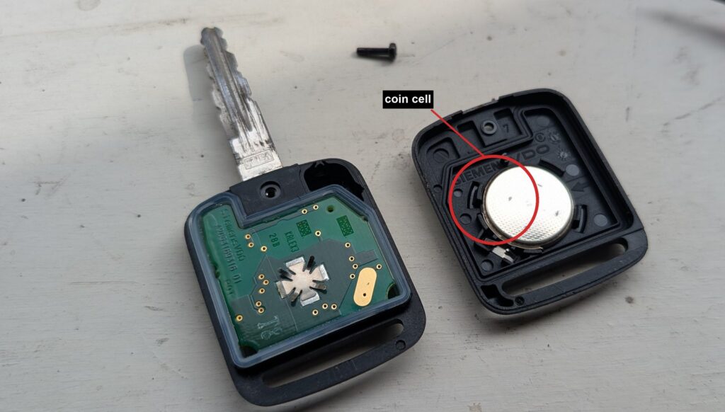 Nissan Qashqai J10 key fob opened, showing the coin cell in the cover