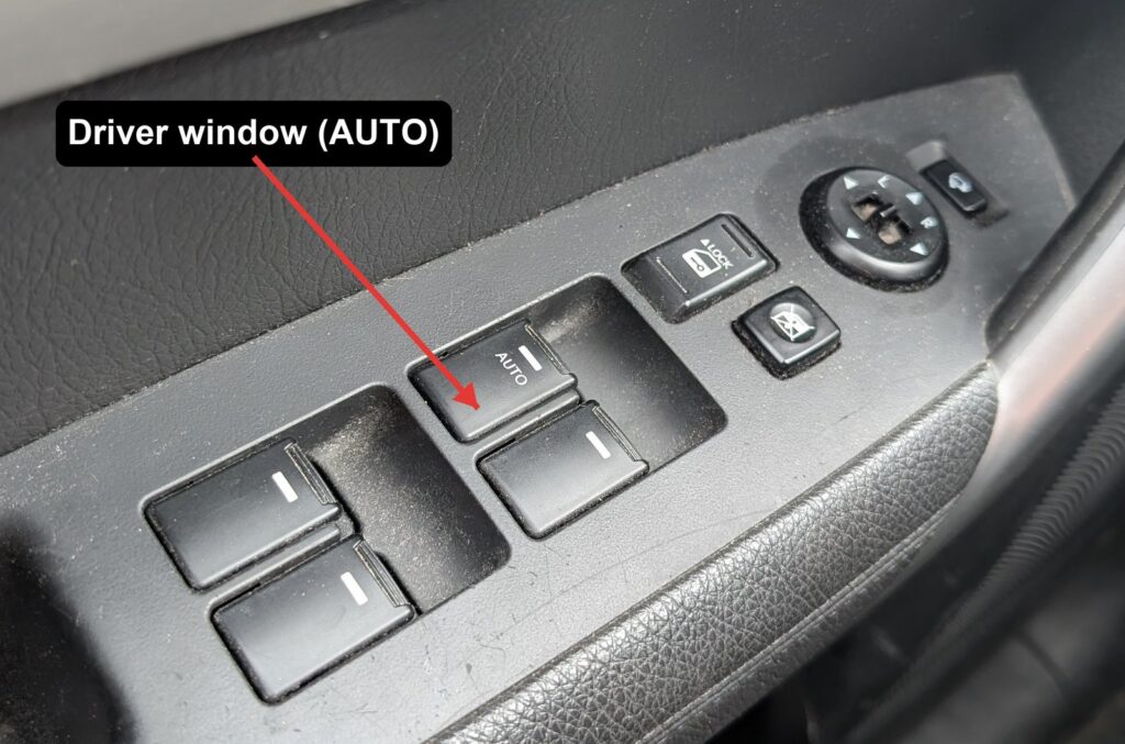 Kia Sorento XM driver door window switches, arrow on the AUTO driver window switch