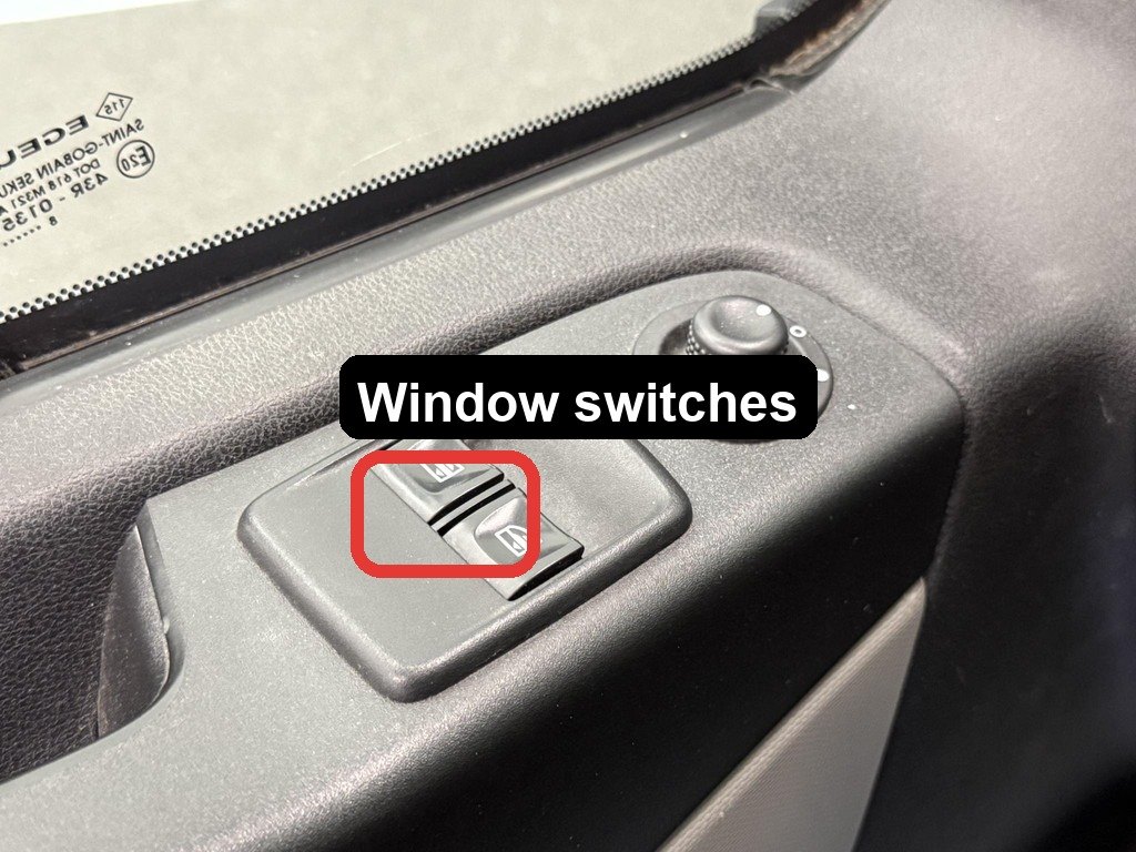 The two electric window switches on the driver&rsquo;s door of the van