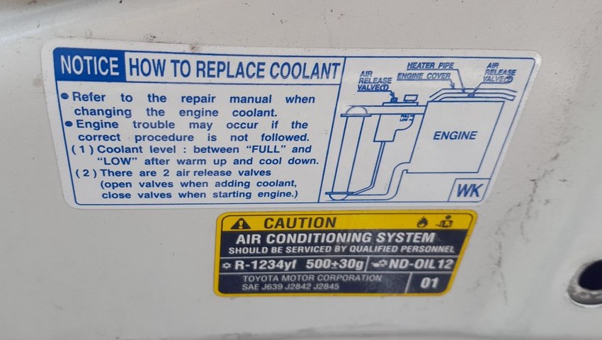 Toyota Hilux under-hood air conditioning label showing R-1234yf refrigerant and 500 g charge