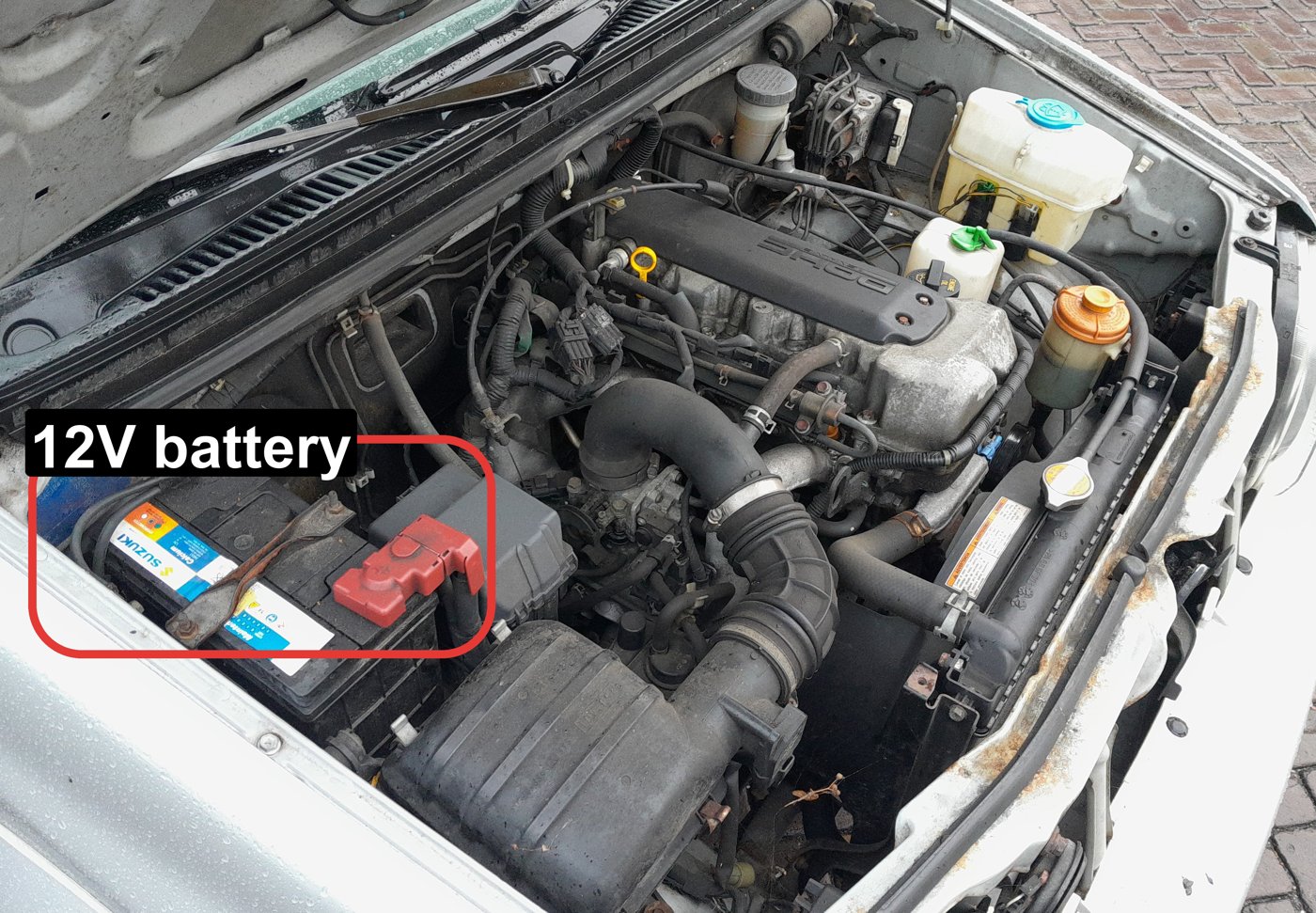 12V battery location in the engine bay of a Suzuki Jimny