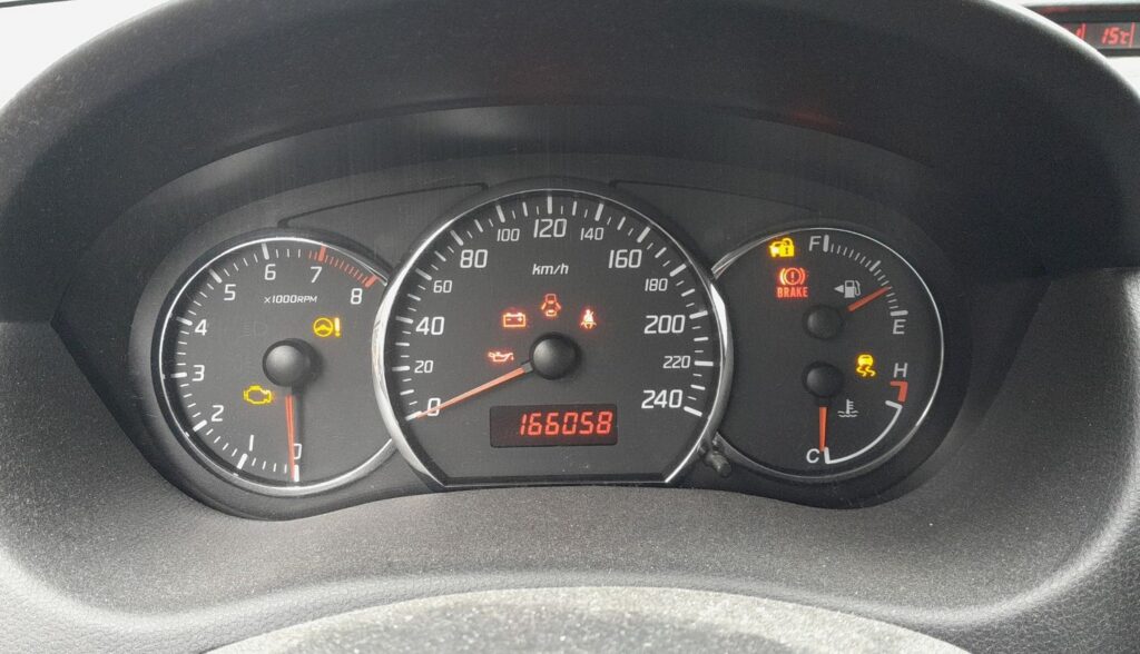 Suzuki Swift instrument cluster with several warning lights lit