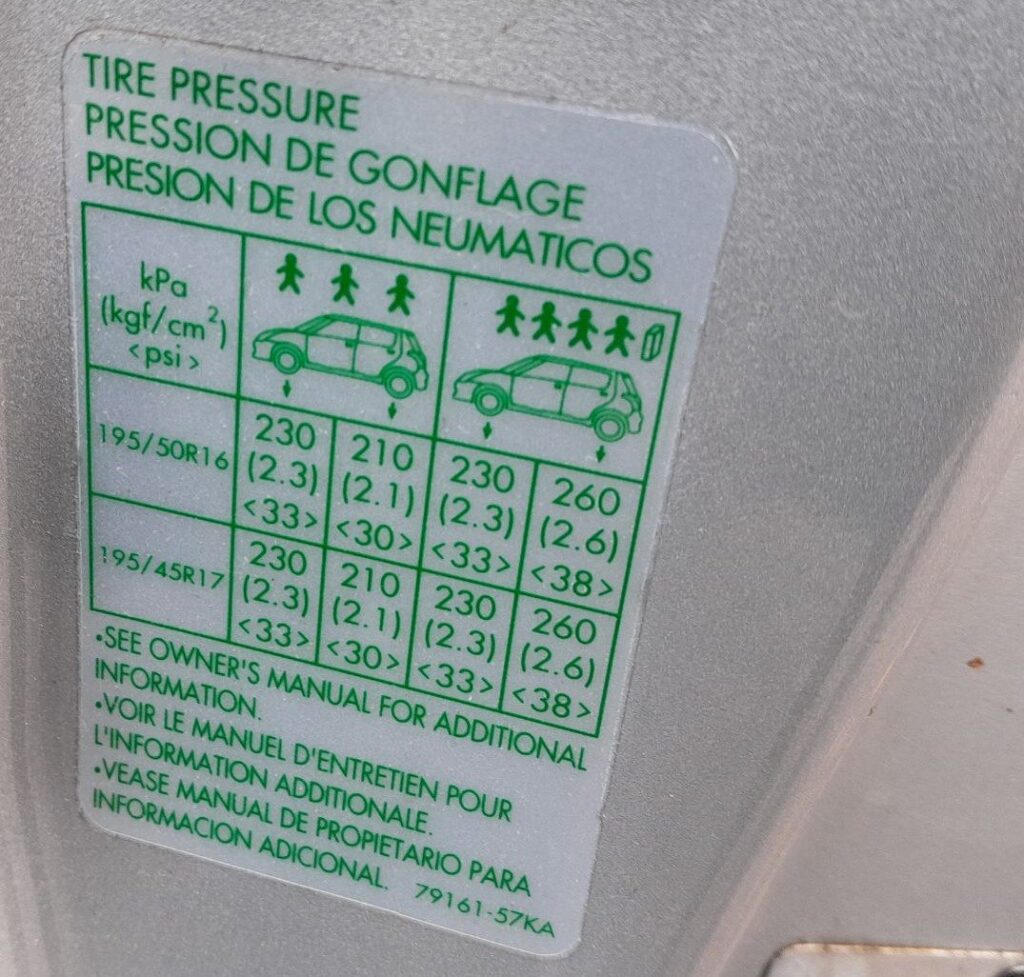 Tire pressure label on a Suzuki Swift door pillar showing 195/50 R16 and 195/45 R17 pressures