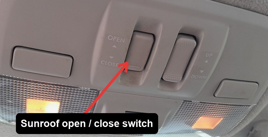 Overhead console sunroof switches on a Subaru XV (GP), with the open/close slide switch arrowed