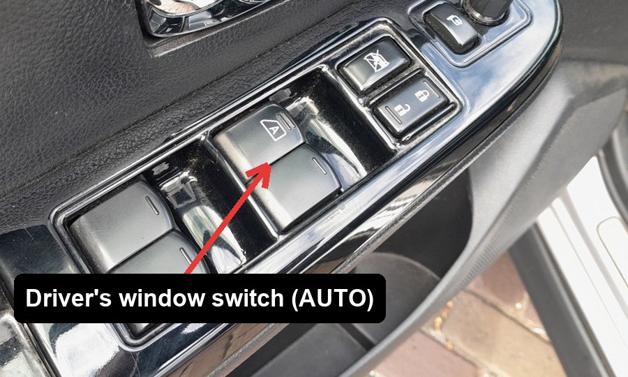 Driver's door power window switch cluster on a Subaru XV (GP), with the driver's AUTO window switch arrowed